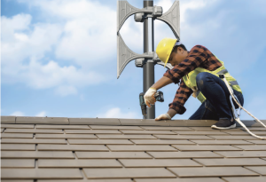 SiRcom technician mounting siren on roof for mass notification emergency safety.