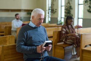 Man holding Holy Bible and rosary beads who is being protectedd by the AI CCTV Cameras integrated by HQE